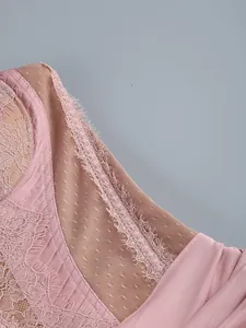 Close-up of pink lace and sheer mesh detailing on a bustier dress