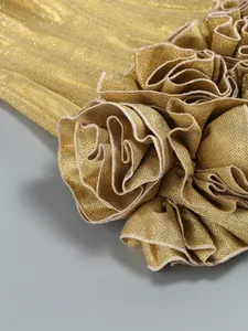 Detailed macro view of the golden metallic shimmery fabric and ruffled rose floral design