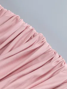 Detailed macro view showing the fine pink ruched pleated fabric texture of a bodycon dress