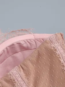 Close-up detail of delicate pink lace edging and mesh texture on elegant evening dress