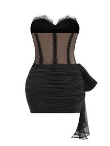 Detailed view of black ruched mini dress with sheer lace bodice and side bow detail.