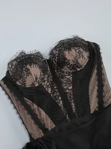 Close-up of elegant black floral lace corset dress with sheer mesh paneling details