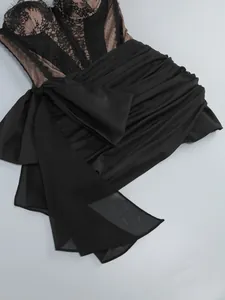 Detail view of black lace corset and satin bow on an elegant evening bodycon dress