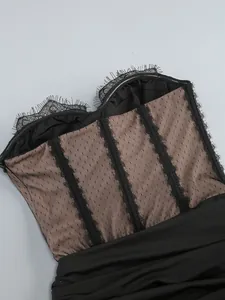 Detailed view of black eyelash lace trim and dotted mesh paneling on a corset dress