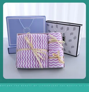 Purple zig-zag towel gift set in a white box with elegant cream ribbons and gift bags.
