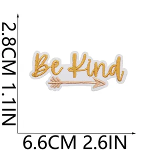 Vue détaillée du patch brodé 'Be Kind' montrant la taille 6,6 cm x 2,8 cm