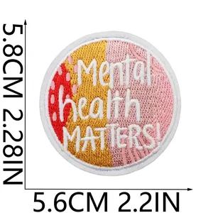 Détail de la texture brodée de l'écusson rond 'Mental health MATTERS!' pour vêtements