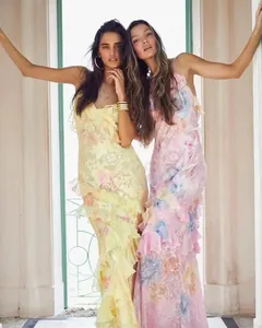 Detailed view of two models in elegant floral ruffled slip dresses on a porch