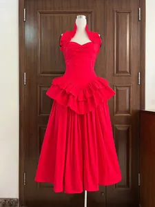 Front view of a vibrant red halter tiered dress with pleated details and corset waist