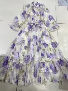 Close-up detail of a floral V-neck midi dress featuring lantern sleeves and a tiered skirt