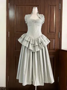 Detailed view of an elegant sage green tiered maxi dress with fishbone corset waist.