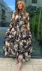 Detailed view of elegant floral tiered maxi dress with lantern sleeves and belted waist.