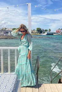 Bohemian floral V-neck tiered maxi dress with lantern sleeves at a seaside resort