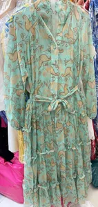 Close-up detail of a light blue paisley floral tiered maxi dress with belted waist