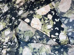 Macro detail of floral print chiffon fabric and metallic buttons on a layered dress