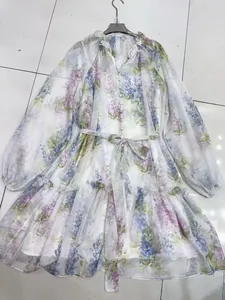 Detailed close-up of a floral V-neck dress with lantern sleeves and a tiered skirt design
