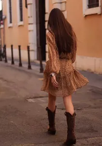 Rear view of a leopard print tiered dress with lantern sleeves in an urban setting
