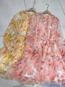 Detailed view of elegant floral chiffon dresses with lantern sleeves and tiered ruffles.