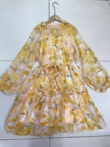 Detailed full-length shot of a yellow floral dress featuring puff sleeves and a waist tie