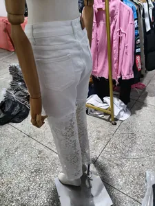 Vue arrière détaillée d'un pantalon blanc taille haute avec ourlet en dentelle