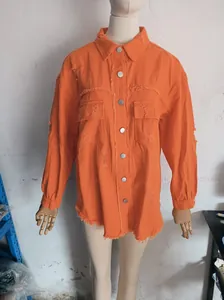 Detail view of an orange distressed denim jacket with frayed edges and button closure.