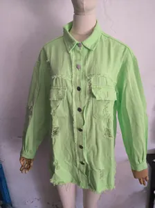 Detailed macro view of a lime green oversized distressed denim jacket featuring ripped holes