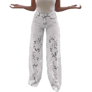 Détail du jean blanc à taille haute et jambe large avec dentelle florale évidée.