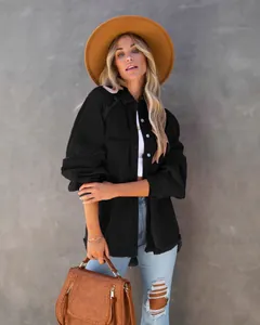 Dettaglio di una giacca di jeans nera lavata da donna con bordi sfilacciati e vestibilità ampia.