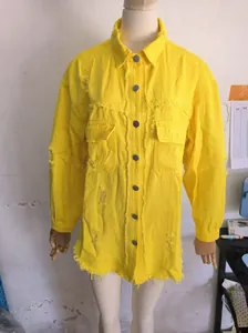 Close-up of yellow oversized distressed denim jacket with frayed edges and pockets