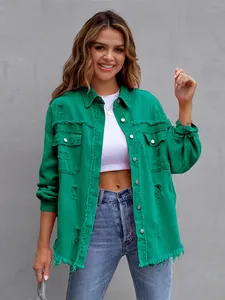 Detailed view of women's green distressed denim jacket featuring fringe hem and button detail