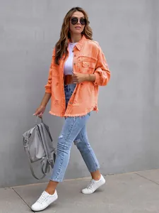 Close-up of a model wearing an orange oversized distressed denim jacket with frayed edges