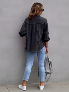 Back view of a loose black distressed denim jacket with frayed hem and ripped details.