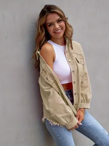 Detailed view of an oversized khaki distressed denim jacket worn by a smiling female model