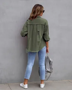 Detailed view of women's distressed olive green denim jacket with frayed hem and rip details