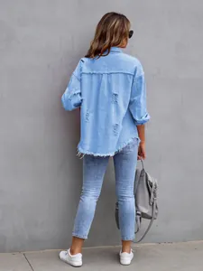 Back view of a light blue distressed denim jacket with frayed hem and loose fit