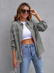 Detailed close-up of a grey oversized denim jacket featuring distressed frayed edges