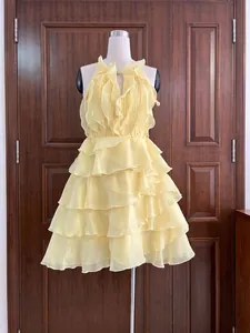 Détail d'une élégante robe jaune à volants en mousseline sur un mannequin d'étalage.