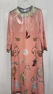 Gedetailleerd overzicht van roze losse jurk met ronde hals en vintage abstracte prints.