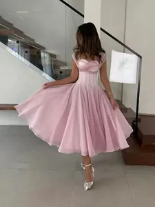 Elegant pink pleated midi dress with corset waist and cap sleeves in a modern setting