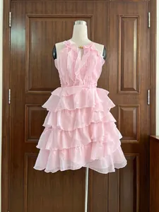Détail d'une mini-robe rose en mousseline à volants avec un décolleté licou élégant