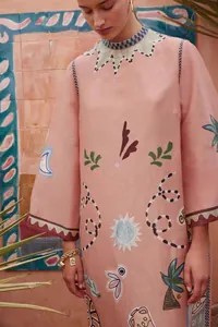 Detail van de retro artistieke prints op een roze losvallende jurk met ronde hals