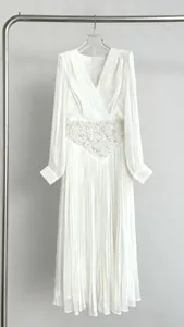 Close-up of elegant white V-neck pleated tulle maxi dress with beaded waist