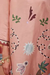 Detailopname van een elegante retro jurk met kleurrijke abstracte zon- en bladmotieven.