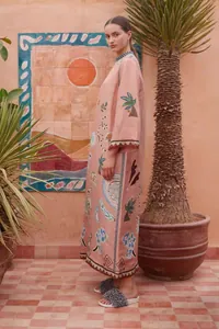 Zijaanzicht van een elegante roze bedrukte kaftanjurk in een bohemien resort omgeving