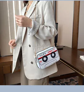 Vintage white cassette tape shaped crossbody bag with gold chain strap detail closeup