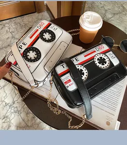 Close-up of retro cassette tape shaped PU cross-body bags with elegant chain straps