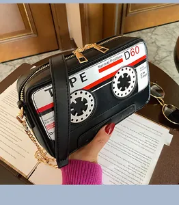 Close-up of a retro cassette tape shaped PU crossbody bag with gold chain strap.