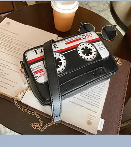 Detail of creative cassette tape shaped crossbody bag with gold chain strap