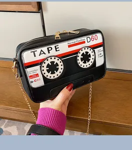 Detailed view of a retro cassette tape shaped crossbody bag with gold chain strap.