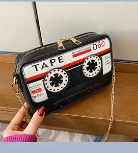 Detail of retro cassette tape shaped PU crossbody bag featuring a golden chain strap